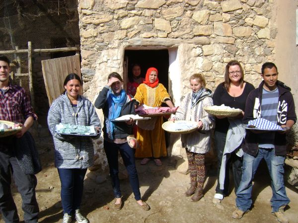 volunteers just made bread and taking it to the oven 