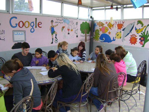 volunteers teaching English to kids at the orphanage